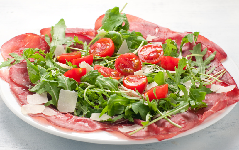 Plate of bresaola with rocket parmesan and cherry tomatoes